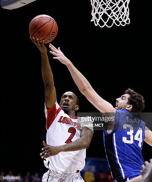 Louisville guard Russ Smith gets this shot past Duke forward Ryan Kelly in second half action in the NCAA regional final game on Sunday, March 31 in...