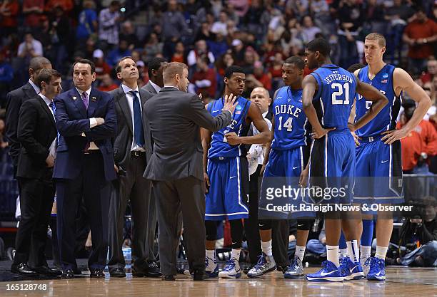 Duke players and coaches gather after Louisville Cardinals guard Kevin Ware broke his leg in the first half of the NCAA Tournament at Lucas Oil...
