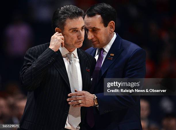 Duke head coach Mike Krzyzewski shares a moment with Louisville head coach Rick Pitino as medical technicians take care of injured Cardinals' guard...