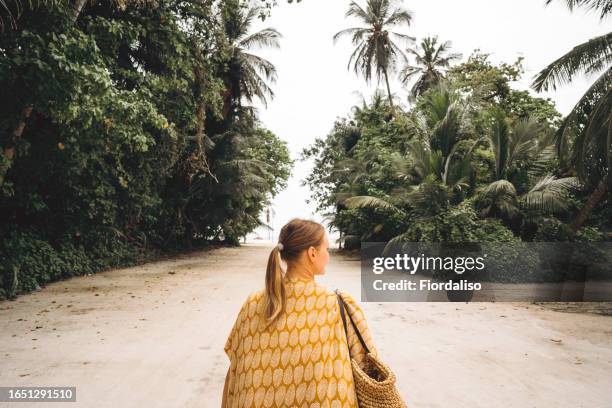 a woman in dress going to the beach - sarongs for women stock pictures, royalty-free photos & images