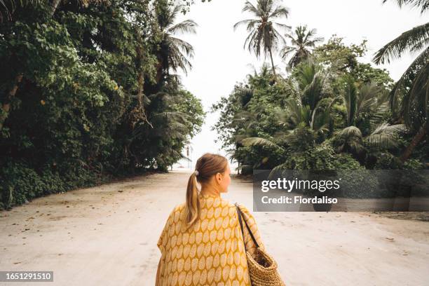 a woman in dress going to the beach - sarong stock pictures, royalty-free photos & images