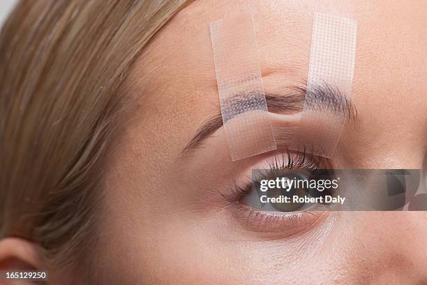 close up of womans eye taped open - eyelid stock pictures, royalty-free photos & images