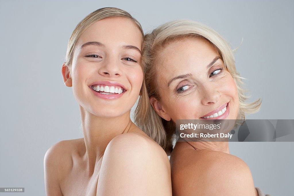 Smiling mother and daughter back to back