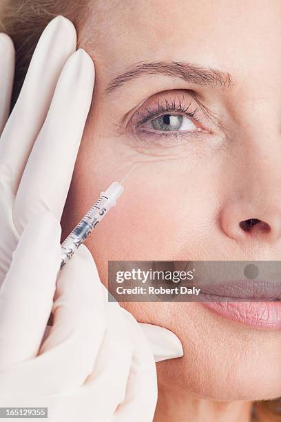 close up of woman receiving botox injection under eye - botox injection stock pictures, royalty-free photos & images
