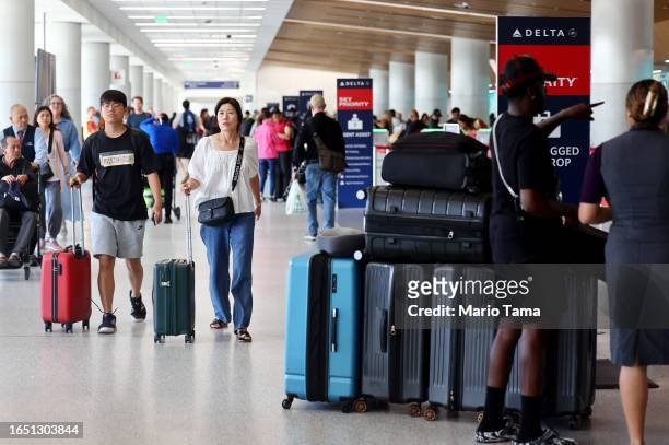 Travelers pass through the Delta terminal at Los Angeles International Airport on August 31, 2023 in Los Angeles, California. Labor Day weekend will...
