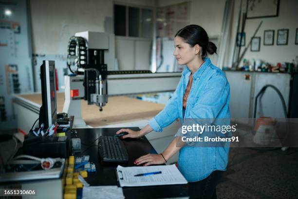 young woman programming a cnc machine computer at sign board making factory - pattern cutting stock pictures, royalty-free photos & images