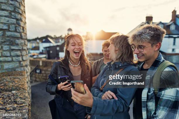 mother and three teenagers sightseeing town of lyme regis, dorset on a summer day - family teenager stock pictures, royalty-free photos & images