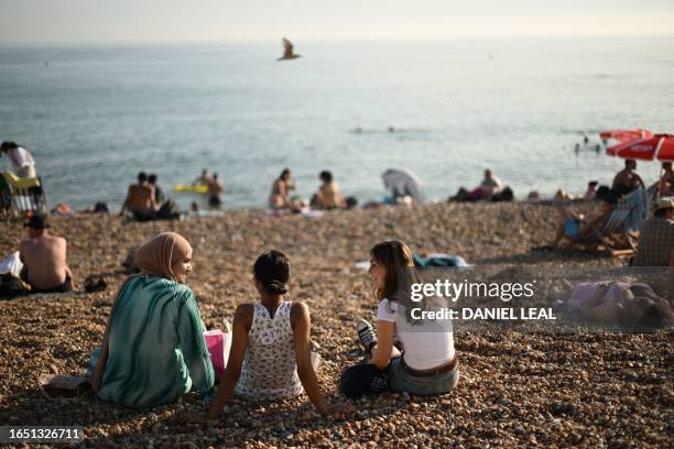 Beachgoers enjoy the sun and the sea on the beach at Brighton, on the south coast of England on September 7 as the late summer heatwave continues.