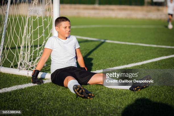 the boy stands in goal and defends. - tween heels stock pictures, royalty-free photos & images