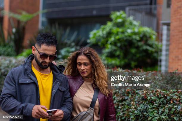 latino brothers are together in the street walking feeling comfortable and calm with a good expression on their face - mario bros stock pictures, royalty-free photos & images