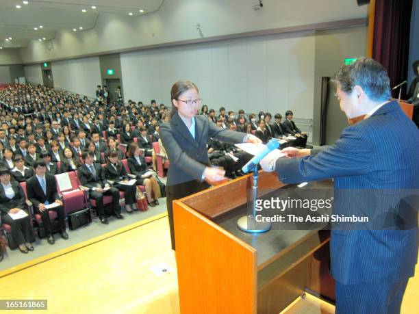 Nagoya City mayor Takashi Kawamura passes a certificate of employment to a new employee during the welcome ceremony on April 1, 2013 in Nagoya,...