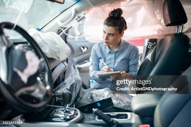 versicherungssachverständiger, der schäden im inneren eines verunfallten fahrzeugs inspiziert. - antragsformular stock-fotos und bilder