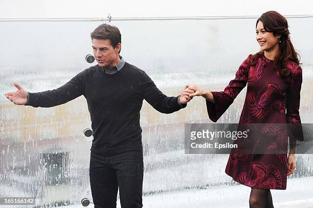 Olga Kurylenko and Tom Cruise attend a photo call of the 'Oblivion' at the Ritz Carlton Hotel on April 1, 2013 in Moscow, Russia.