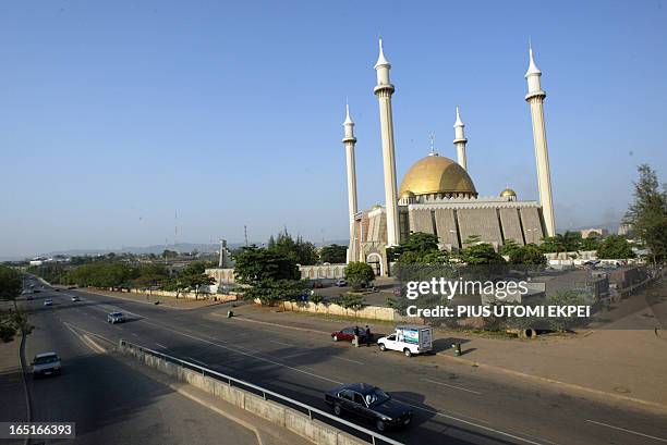 Motorists drive past the national central mosque in Abuja 27 November, 2006. Nigeria's federal capital, which is poised to host an OPEC meeting in...