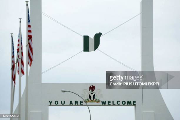 Flags of the United States of America are displayed at the Abuja city gate, 10 July 2003, ahead of United States President George W. Bush's visit to...