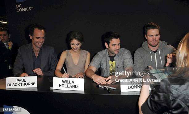 Actors Paul Blackthorne, Colin Donnell, Willa Holland, Stephen Amell of The WB's "Arrow" signs autographs at the DC Comics booth at WonderCon Anaheim...