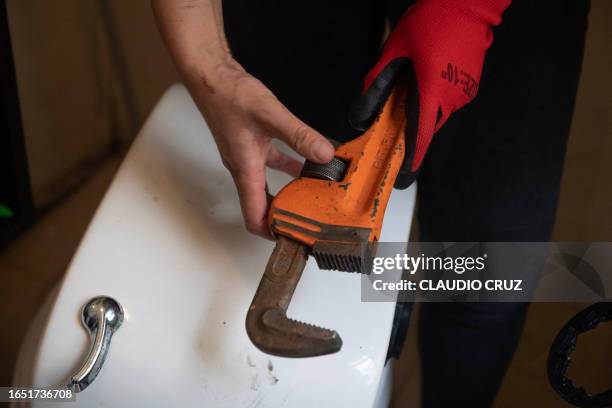 Mexican plumber Berenice Aparicio repairs a toilet at a private home in Mexico City on August 31, 2023. A female president in Mexico for the first...