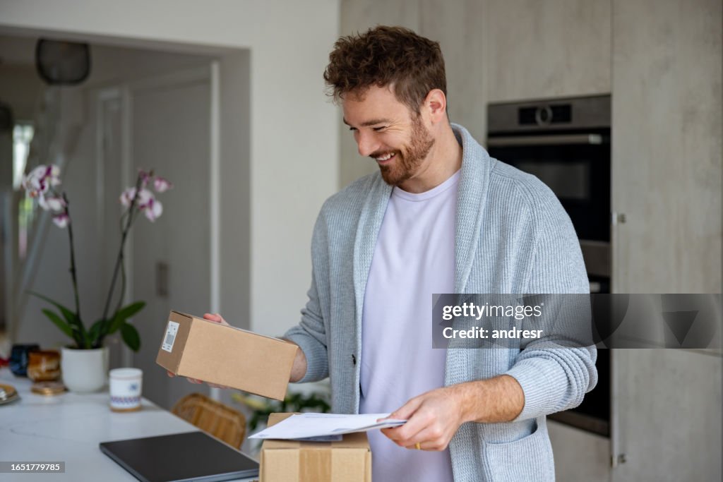 Happy man at home checking the mail and reading a letter