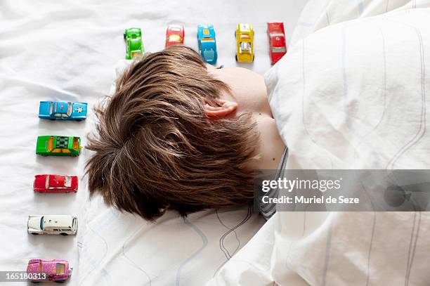 boy sleeping with toy cars - toy cars photos et images de collection