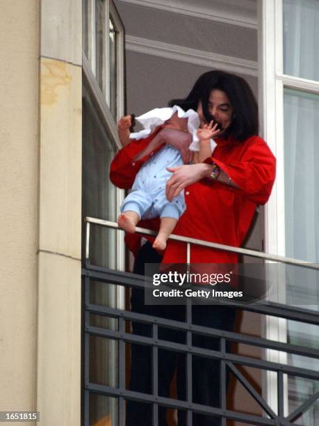 Singer Michael Jackson holds his son eight-month-old son Prince Michael II over the balcony of the Adlon Hotel November 19, 2002 in Berlin, Germany....