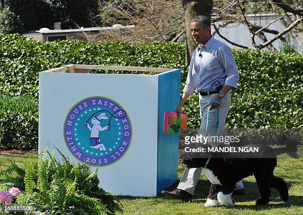 President Barack Obama walks with Bo, the family dog, as he arrives to read a story to children attending the annual Easter Egg Roll on April 1, 2013...