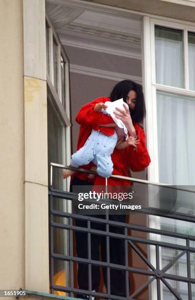 Singer Michael Jackson holds his eight-month-old son Prince Michael II over the balcony of the Adlon Hotel November 19, 2002 in Berlin, Germany....