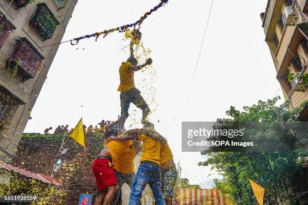 Hindu devotees make a human tree to break a mud made container full of curd as they take part in competition during the celebration of Janmashtami...