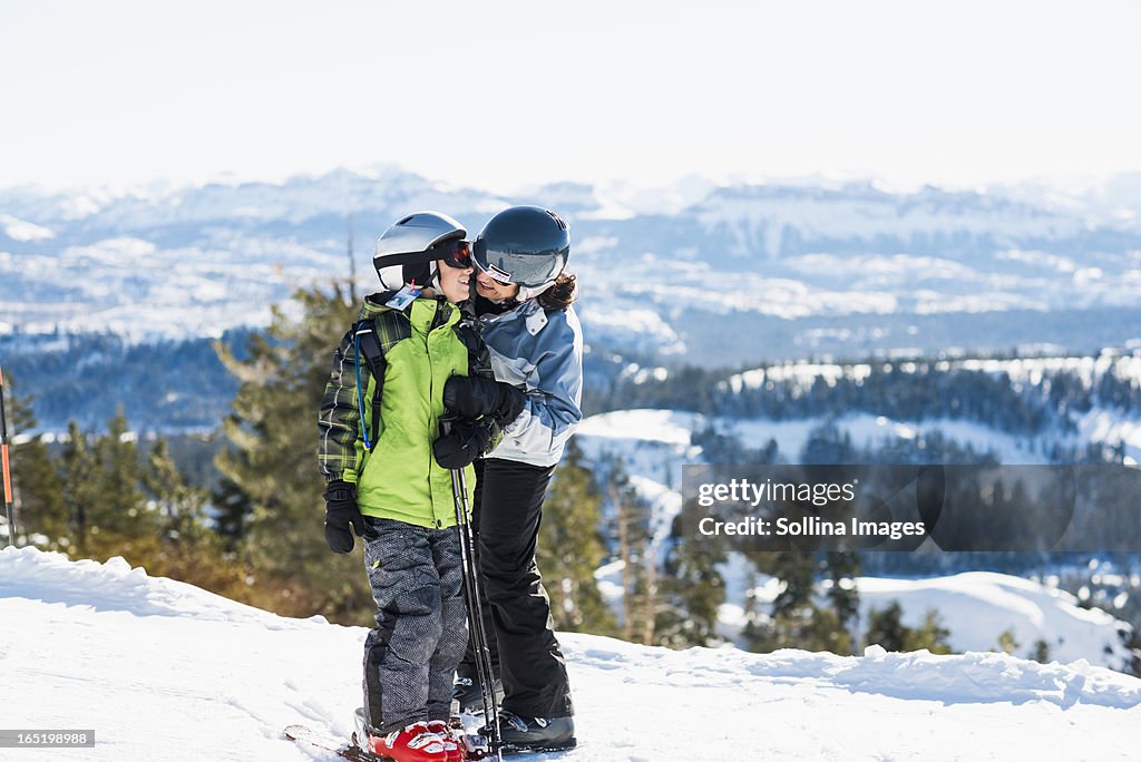 Mother and son wearing skis talking