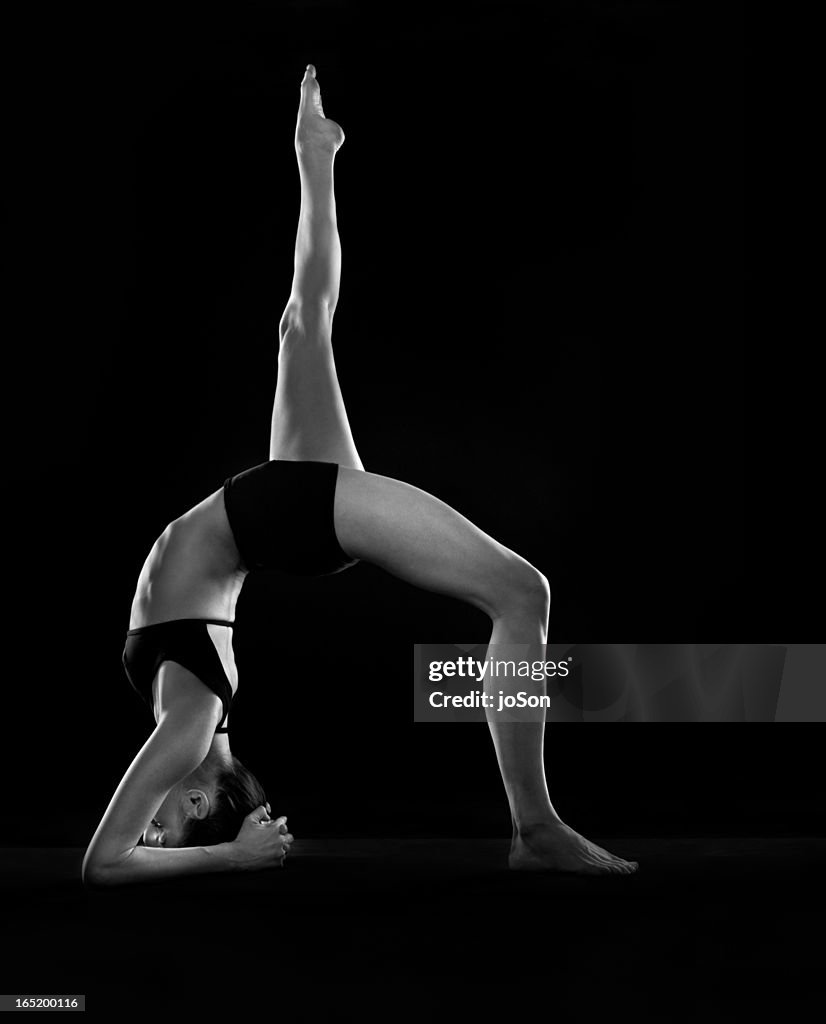 Woman doing one-legged inverted staff pose II