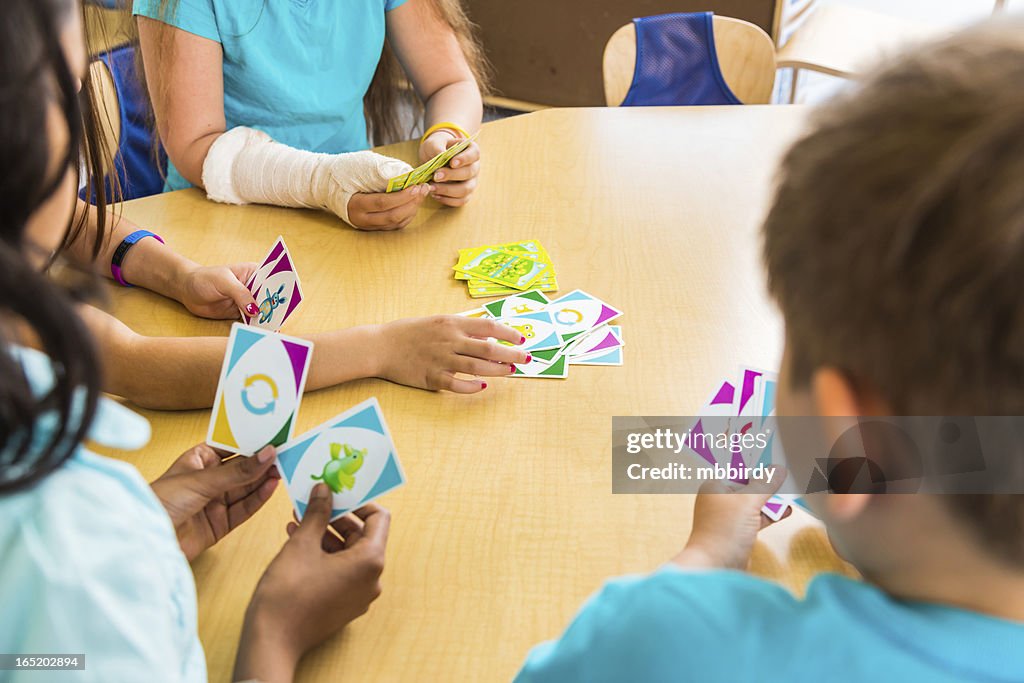 School children playing card game