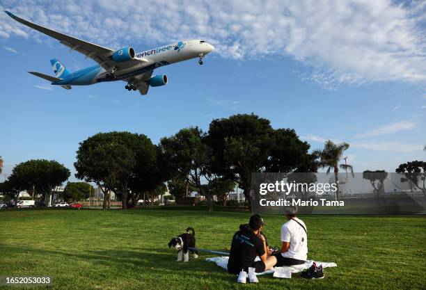 People view a French bee airplane landing while sitting in a park next to Los Angeles International Airport on August 31, 2023 in Los Angeles,...