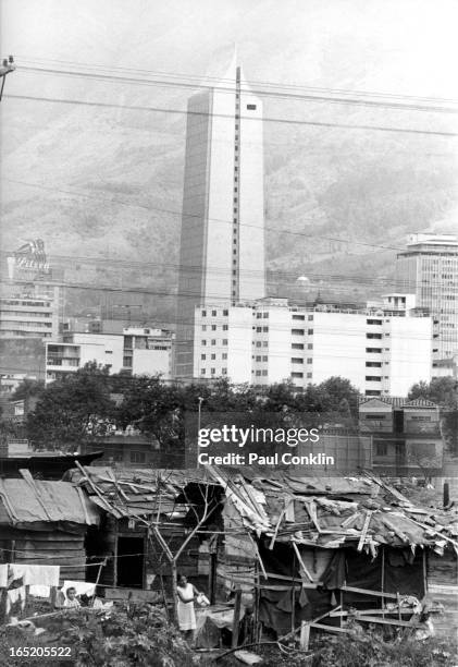 The Coltejer building, a newly built skyscraper, rises behind shacks, Medellin, Colombia, 1970s.