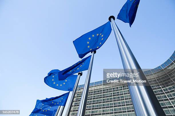 european flags in front of the berlaymont building in brussels - unión europea stock pictures, royalty-free photos & images