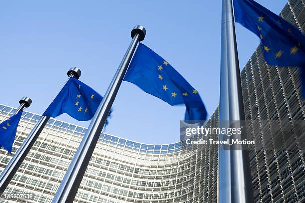 european flags in front of the berlaymont building in brussels - berlaymont stock pictures, royalty-free photos & images