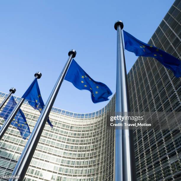 european flags in front of the berlaymont building in brussels - berlaymont stock pictures, royalty-free photos & images