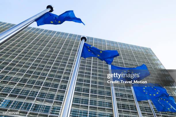 european flags in front of the berlaymont building in brussels - berlaymont stock pictures, royalty-free photos & images