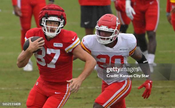 Kansas City Chiefs tight end Travis Kelce runs with the ball as safety Justin Reid pursues during training camp at Missouri Western State University...