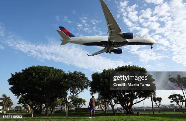 Person views a Delta Airlines plane landing from a park next to Los Angeles International Airport on August 31, 2023 in Los Angeles, California....