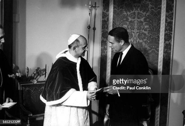 Italian-born Pope Paul VI receives a letter presented by Peace Corps founder and president Sargent Shriver , during the latter's around-the-world...