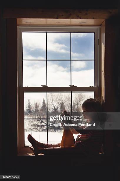 girl in window sill playing with dolls - barefoot snow stock pictures, royalty-free photos & images