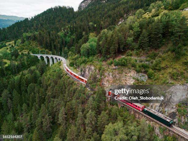 aerial view of red train on viaduct in swiss alps - glacier express stock pictures, royalty-free photos & images