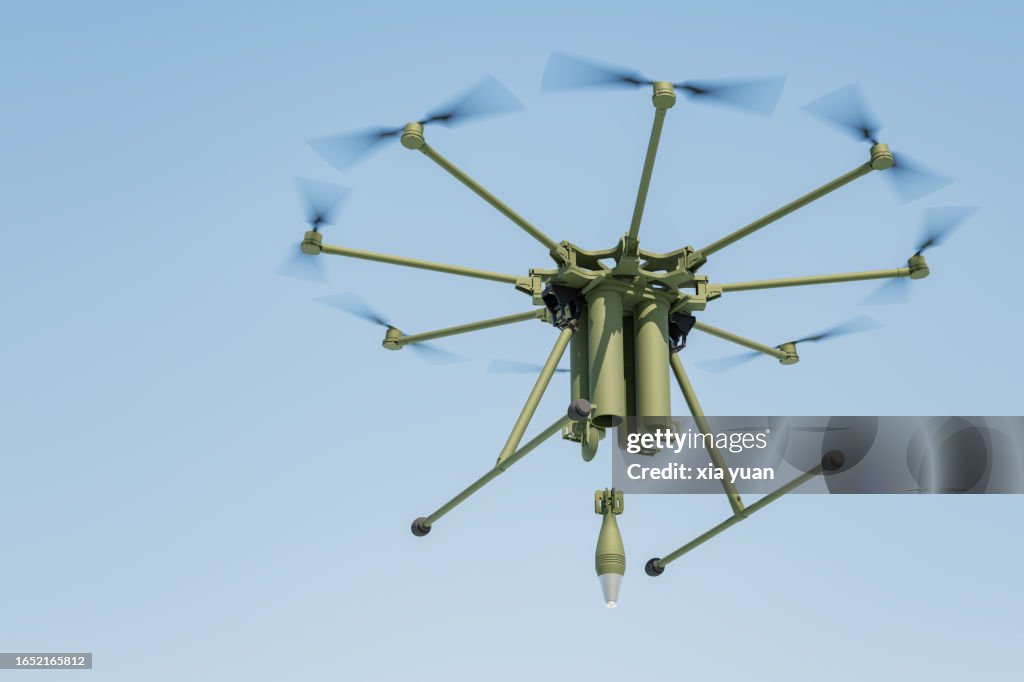 Military drone dropping bomb in blue sky