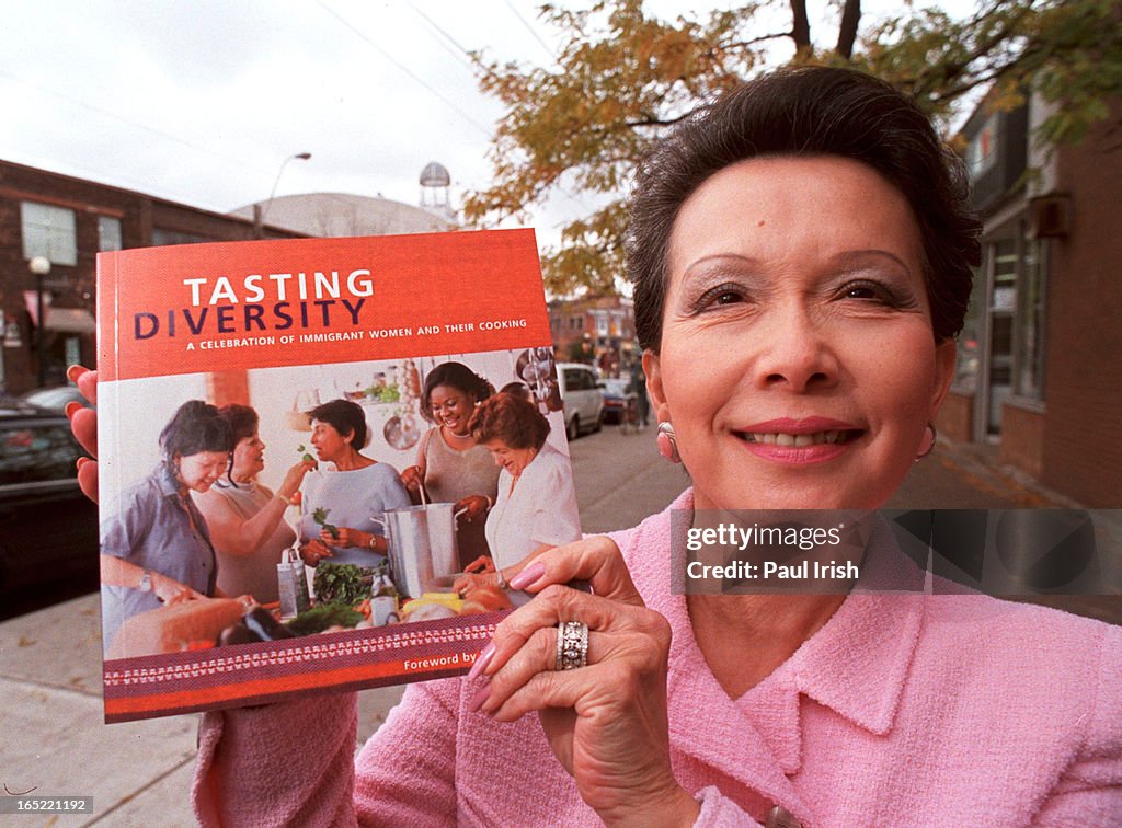 Senator Vivienne Poy holds cookbook that she has contributed with proceeds going to the United Way a