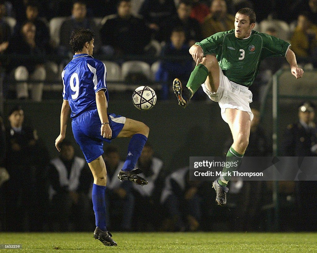 Richard Dunne of Ireland challenges Angelos Charisteas