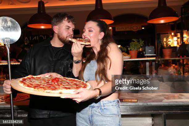 Adrian Louis and Joelina Drews with a pizza during the "A WorldChanger story by L'Osteria" charity event on September 7, 2023 in Munich, Germany.