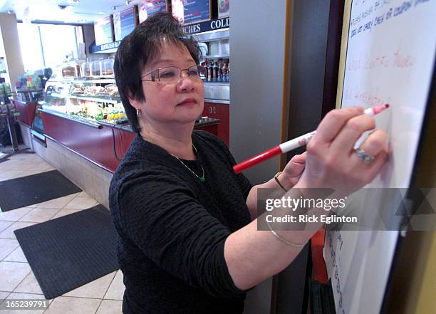 08145324Rick Eglinton Toronto Star.Blanca Suen owner of Timothy's Coffee shop at Charles and Bay posts a Quizz question for her customers.The first...