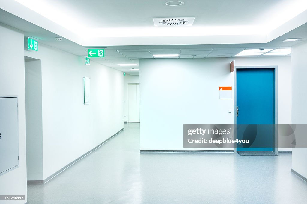 Corredor do Hospital vazio branco com a porta azul