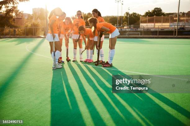 strengthening bonds: team huddled together in the distance - youth sports competition stock pictures, royalty-free photos & images