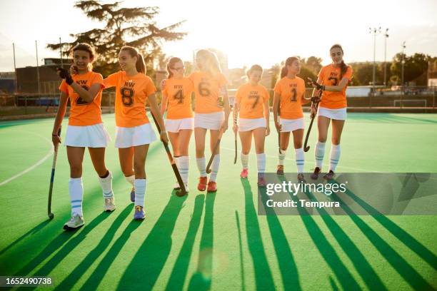 team unity: full squad departs the field at sunset - youth sports competition stock pictures, royalty-free photos & images