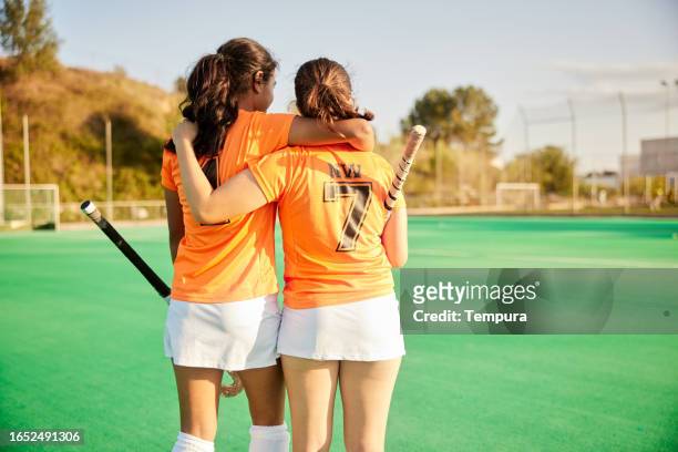 teammates in victory: female teen field hockey players leave the field together - youth sports competition stock pictures, royalty-free photos & images